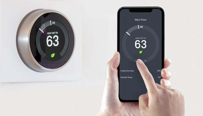 A Nest smart thermostat installed in a contemporary home, showing an active temperature control screen.