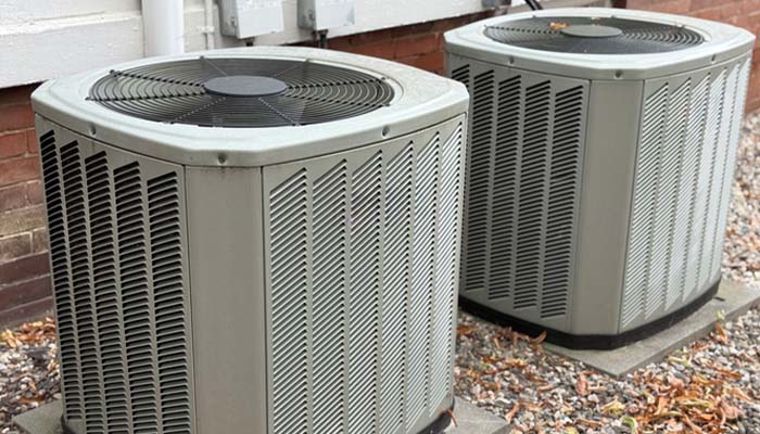 HVAC technician installing a new residential air conditioning unit outdoors.