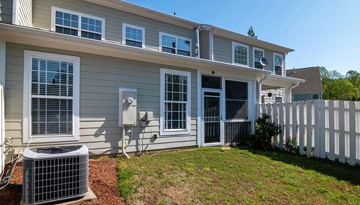 A certified HVAC technician examining an outdoor AC unit during a residential repair appointment in Columbus, Ohio