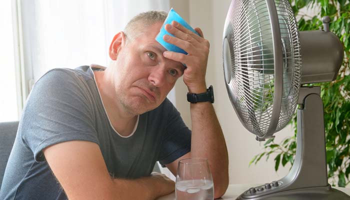 Homeowner checking a thermostat on an air conditioner that won't cool