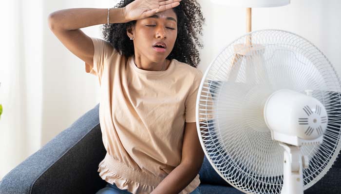 Technician evaluating an aging HVAC system for repair or replacement