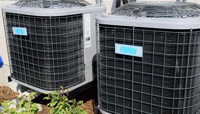 HVAC technician inspecting an air conditioning unit during a routine checkup