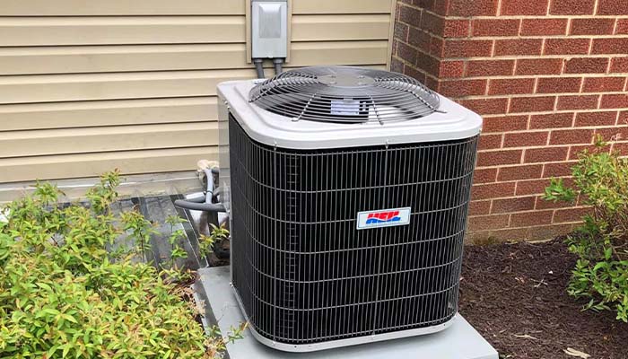 HVAC technician performing spring maintenance on an outdoor air conditioning unit