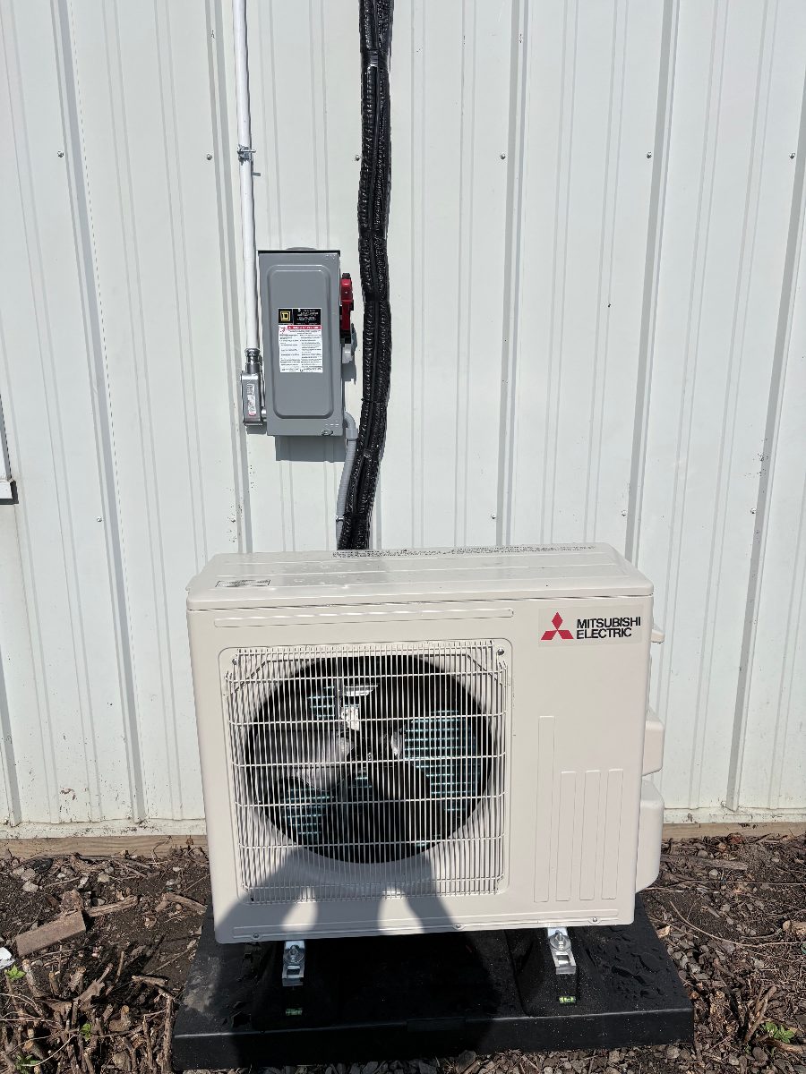 Mitsubishi Electric 20 SEER mini split outdoor heat pump unit set on a pad in New Albany, Ohio